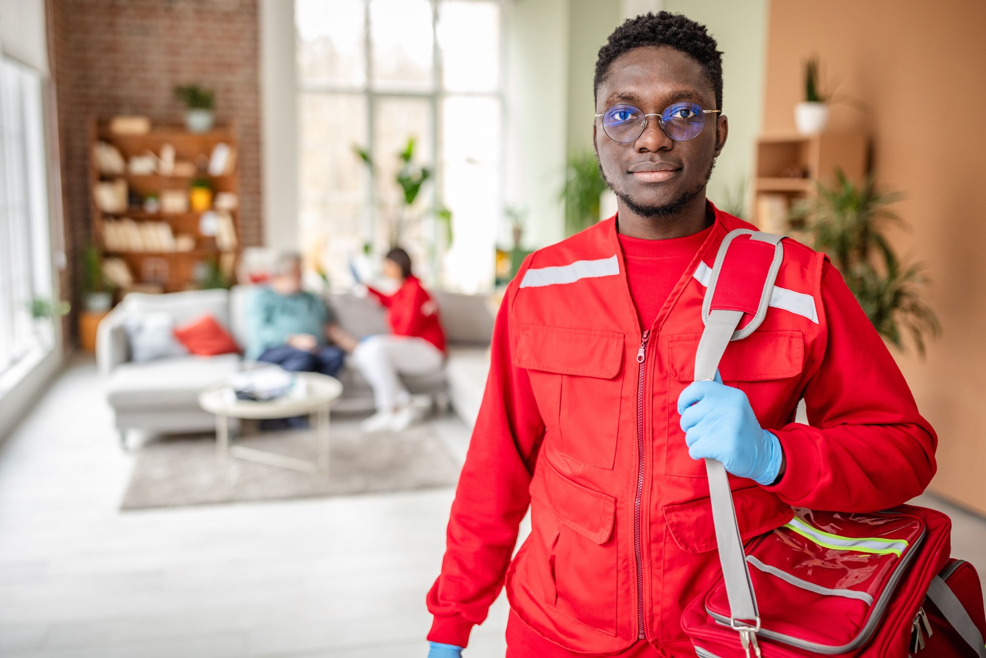 Young paramedics provide assistance to senior man in his home while addressing health concerns